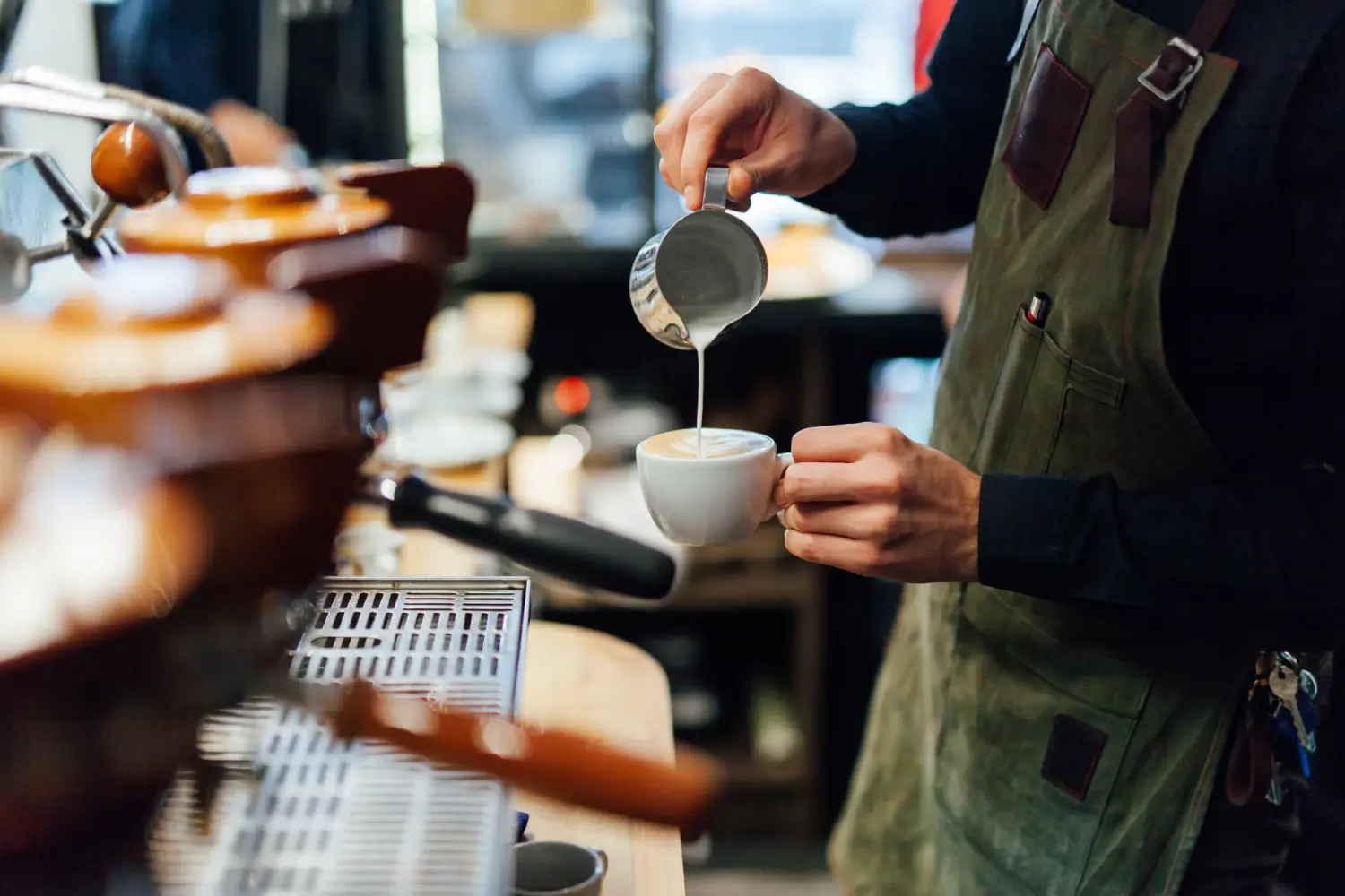 Tress Kaffee, Barista macht Kaffee im Café, Hände halten Tasse Kaffee.